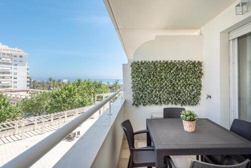 balcón con mesa, sillas y vistas al océano en Apartamento Vista Azul, en Marbella