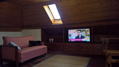 a living room with a couch and a television at Hostel Casal São João in Ribeira Brava