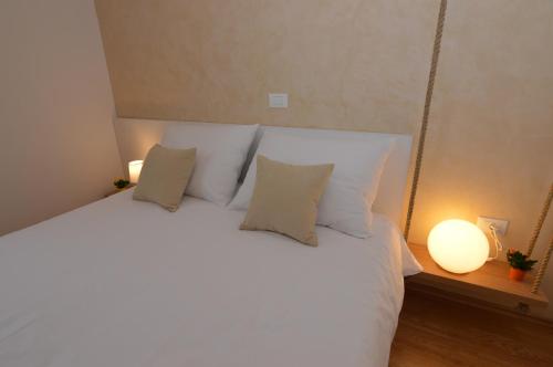 a bedroom with a large white bed with pillows at Hotel Natura Vilanija in Umag