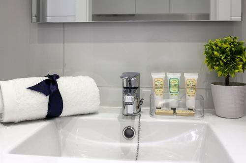 a bathroom counter with a sink with a coffee maker and towels at Habitat Apartments ADN in Barcelona