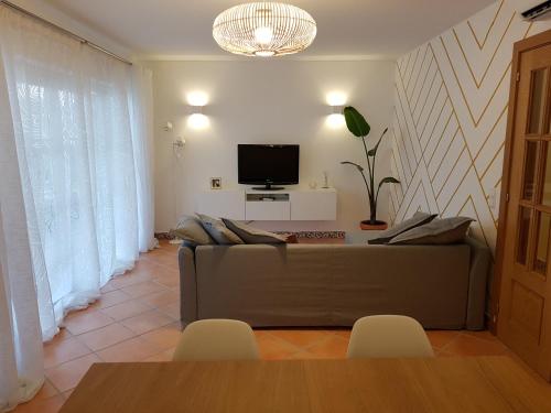 a living room with a couch and a tv at Caia Formosa T1 in Cabanas de Tavira