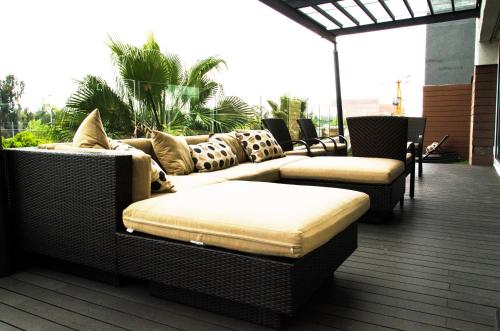 a patio with couches and chairs on a deck at Casa Inn Business Hotel Celaya in Celaya