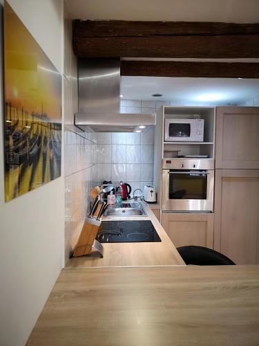 une cuisine avec un évier et un micro-ondes dans l'établissement Studio Centre Historique Aix-en-Provence, à Aix-en-Provence