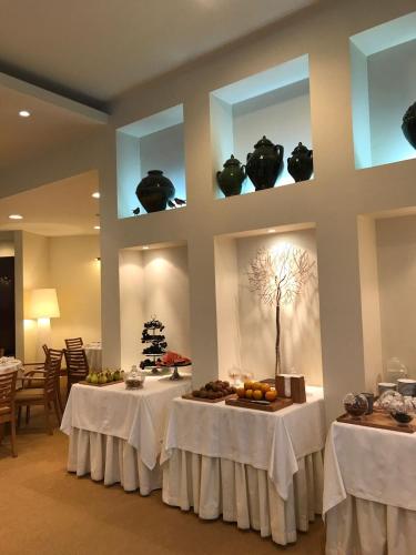 a dining room with two tables with white table cloth at Hotel Santa Maria in Fátima