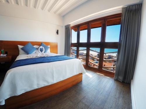 a bedroom with a bed and a large window at Hotel Festival Plaza Playas Rosarito in Rosarito