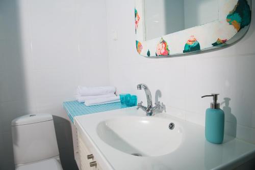 Un baño con lavabo, espejo e inodoro. en Koivulan Kartano, en Lohja