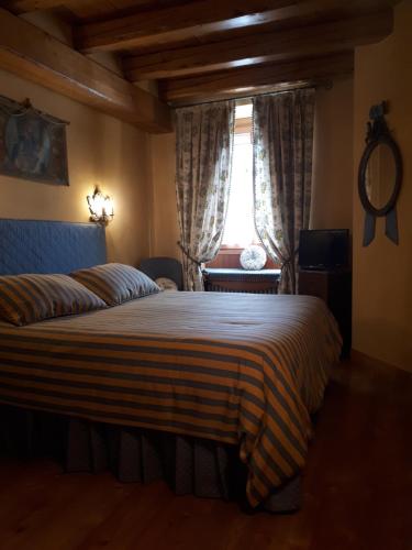 a bedroom with a large bed and a window at L’Invólt Mountain Lodge in Borno
