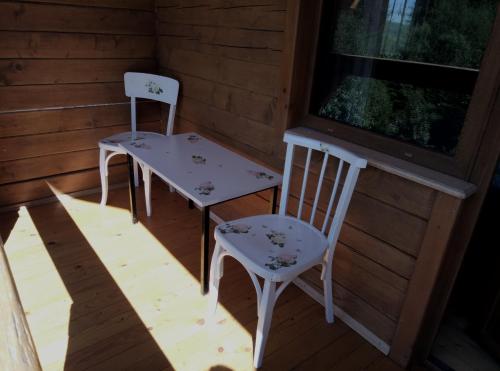 2 sillas y una mesa en un porche en WoodDream, en Volovets