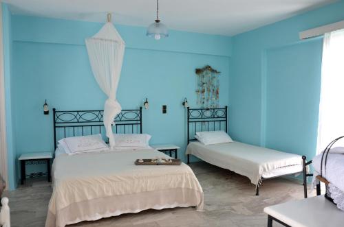 2 camas en una habitación azul con 2 camas sidx sidx sidx en Nufaro, en Naxos Chora