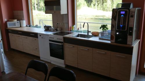 una cocina con fregadero y estufa horno superior en Metsjärve puhkemaja, en Puskaru