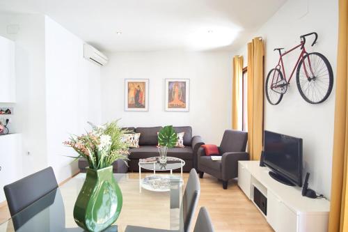 sala de estar con sofá y bicicleta en la pared en Bordador Bicycle City Center by Valcambre, en Sevilla
