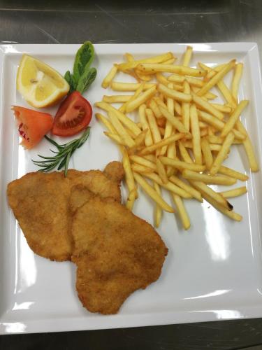 a white plate with french fries and fish and chips at Residence Terentis in Terento