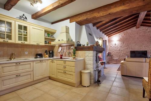 a kitchen with white cabinets and a stone fireplace at Villa Sujevic in Motovun