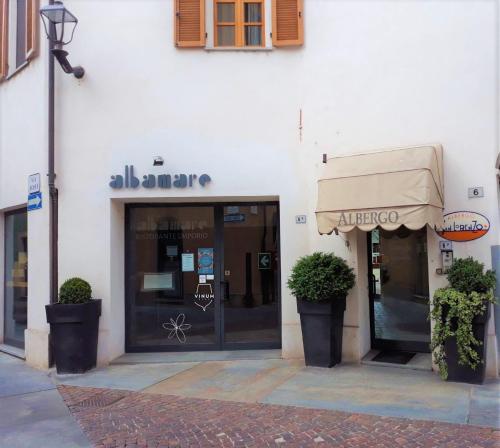 un negozio di fronte a un edificio con piante di fronte ad esso di Albergo San Lorenzo ad Alba