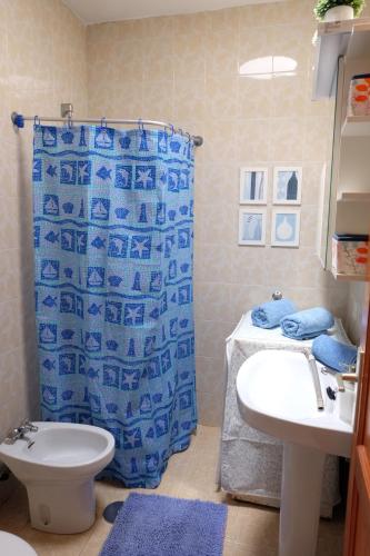 アリエタにあるSEA & RELAX - Apartament 2 drchaのバスルーム(青いシャワーカーテン、シンク付)