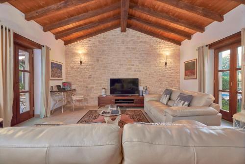 a living room with two couches and a tv at Villa Sujevic in Motovun