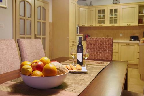 a bowl of fruit on a table with a bottle of wine at Villa Sujevic in Motovun