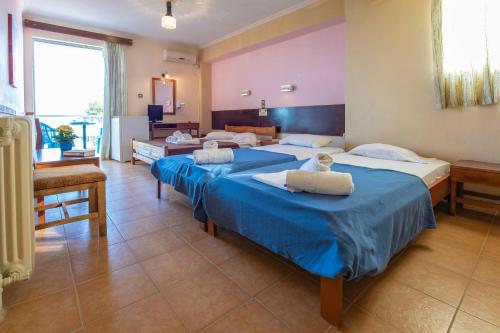 2 camas en una habitación con sábanas azules en Sun Hotel, en Kineta