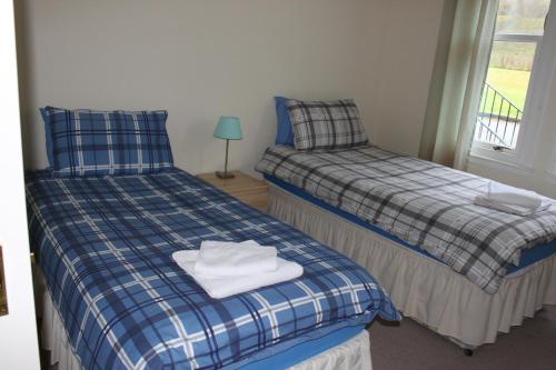 ロッホゴイルヘッドにあるCarrick Farm Lochside Appartment (GF)のベッド2台 ベッドの上にタオルが備わる客室です。