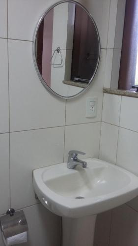 y baño con lavabo y espejo. en Clube Praiano, en Cabo Frío