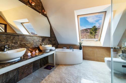 a bathroom with two sinks and a tub at Pałac Margot Nature&SPA in Karpacz