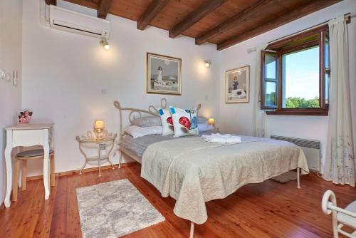a bedroom with a bed and a table and a window at Villa Sujevic in Motovun
