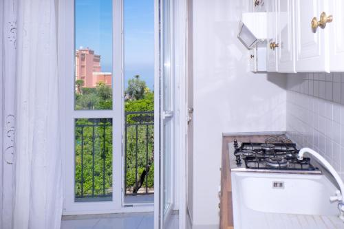 een keuken met een fornuis en een raam met uitzicht bij "White Mermaid" - SORRENTO DOWNTOWN SEA VIEW APARTMENT in Sorrento