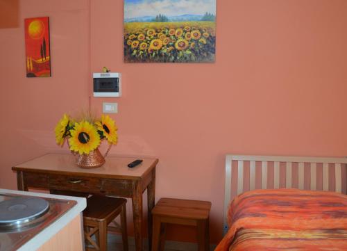 Un dormitorio con una mesa con un jarrón de girasoles. en Casale Re di Coppe, en Lanciano