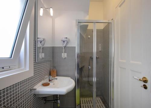 une salle de bain avec un lavabo et une douche dans l'établissement Cantinho do SAL Apartamento T3, à Aveiro