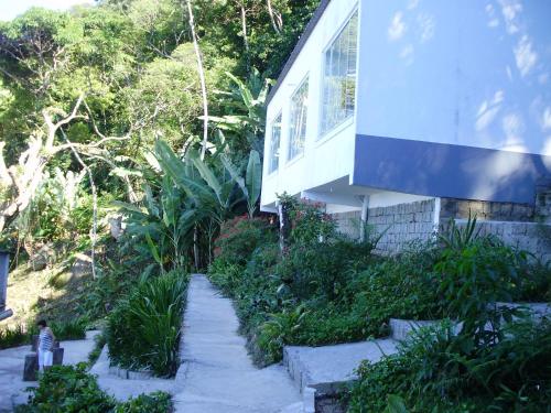 a house with a path next to a building at Pousada Piquara in Mangaratiba