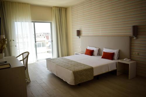 a hotel room with a bed and a large window at Ouril Hotel Agueda in Sal Rei
