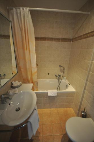 a bathroom with a sink and a tub and a toilet at Hotel Splendid in Montreux