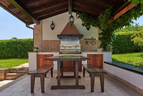 an outdoor kitchen with a table and two benches at Villa Sujevic in Motovun
