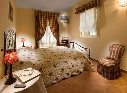 a bedroom with a large bed and a chair at La Tenuta Del Giglio in Tavullia