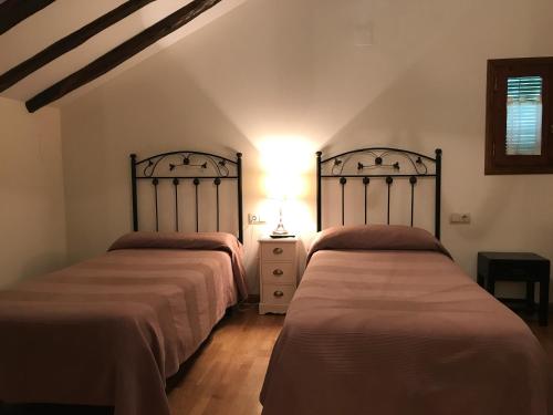 a bedroom with two beds and a lamp on a dresser at Casa Campo in Abay