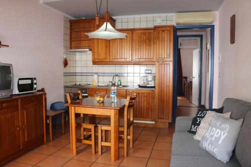a living room with a table and a kitchen at Apartamentos Turisticos Verdemar in Horta