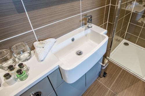 a bathroom with a white sink and a shower at Heathmount Hotel in Inverness