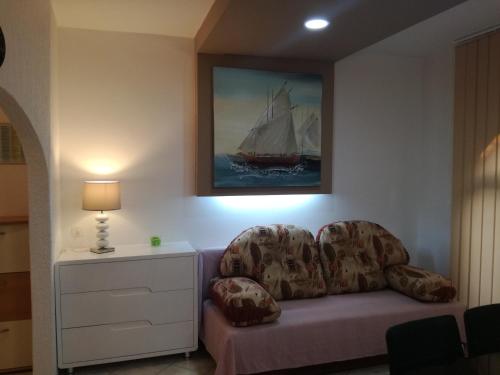 a couch in a living room with a painting of a sail boat at Apartments Barbara in Pinezici
