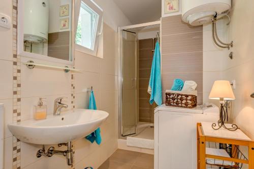 a bathroom with a sink and a shower at Holiday Home Figa in Omiš