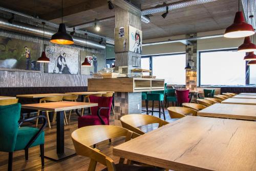 a restaurant with wooden tables and chairs and windows at HOTEL 63 in Poprad
