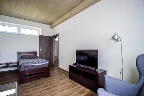 a bedroom with a bed and a tv and a chair at HOTEL 63 in Poprad