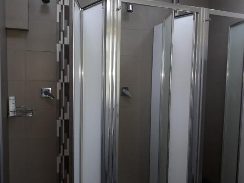 a shower with two glass doors in a bathroom at Hostel Sopot Centrum in Sopot