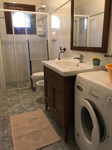 ein Badezimmer mit einer Waschmaschine und einem Waschbecken in der Unterkunft Appartamenti LaConia Cannigione in Cannigione