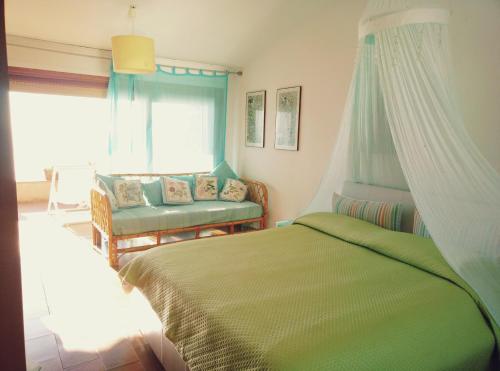 モンテ・アルジェンターリオにあるPorto S.Stefano CalaPiccolaのベッドルーム1室(ベッド1台、椅子、窓付)