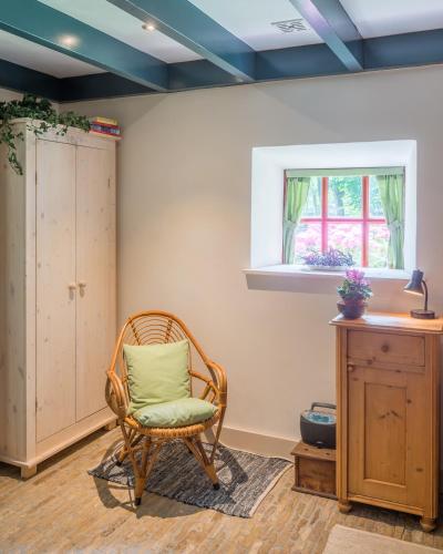 a room with a rocking chair and a window at de Boskpleats in Winsum