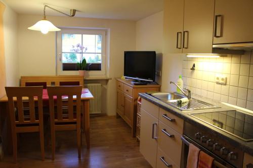 a kitchen with a sink and a table and a television at Apart Wehrmeister in Jungholz