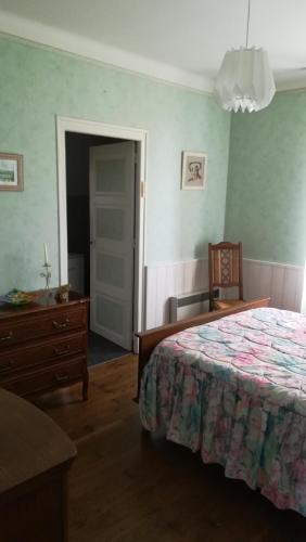 une chambre avec un lit, une commode et une table dans l'établissement Chez Mamie, à Beynat