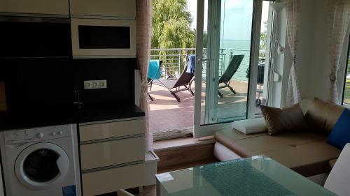 ein Wohnzimmer mit einem Sofa und einem Balkon in der Unterkunft Apartment Balaton in Siófok