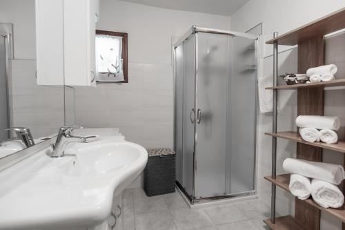 uma casa de banho branca com um lavatório e um chuveiro em Casa Dantina Stenico em Stenico