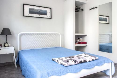 Un dormitorio con una cama blanca con una manta azul. en Athens 8 min from Acropolis, en Atenas